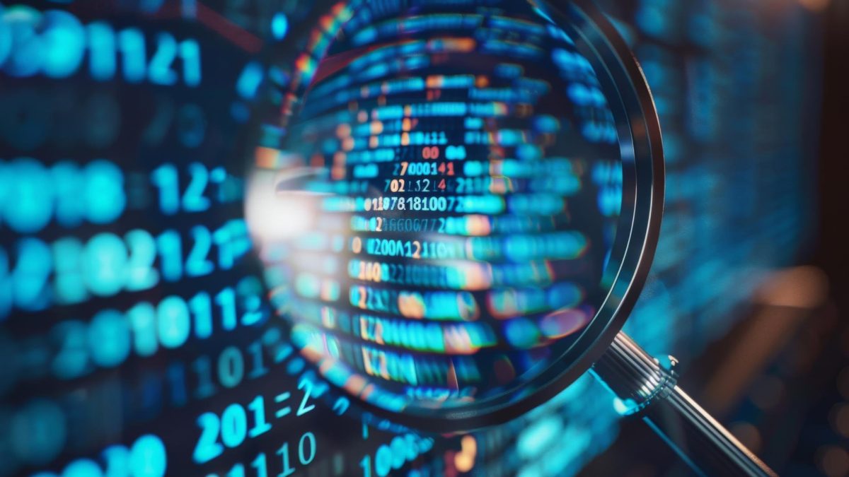 Una persona observando con lupa un código de desarrollo de software